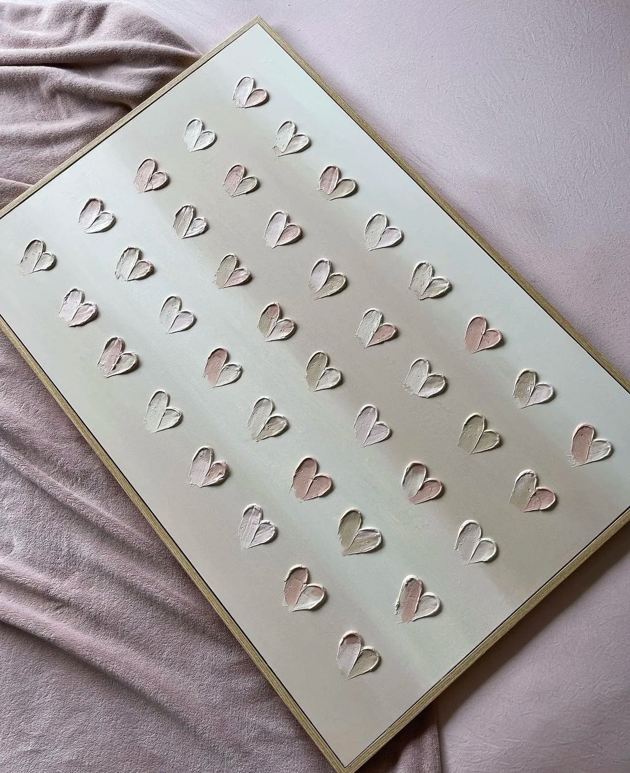 Sheet of cut-out heart shapes on a light background