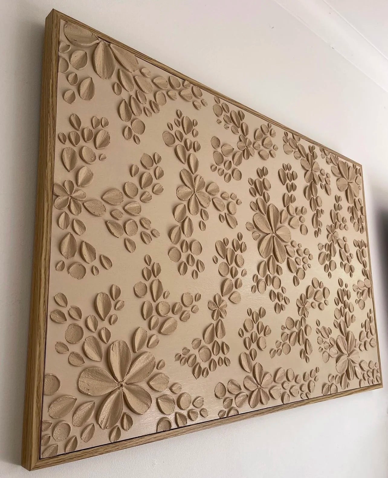 Textured artwork with a  floral patterns on a white wall