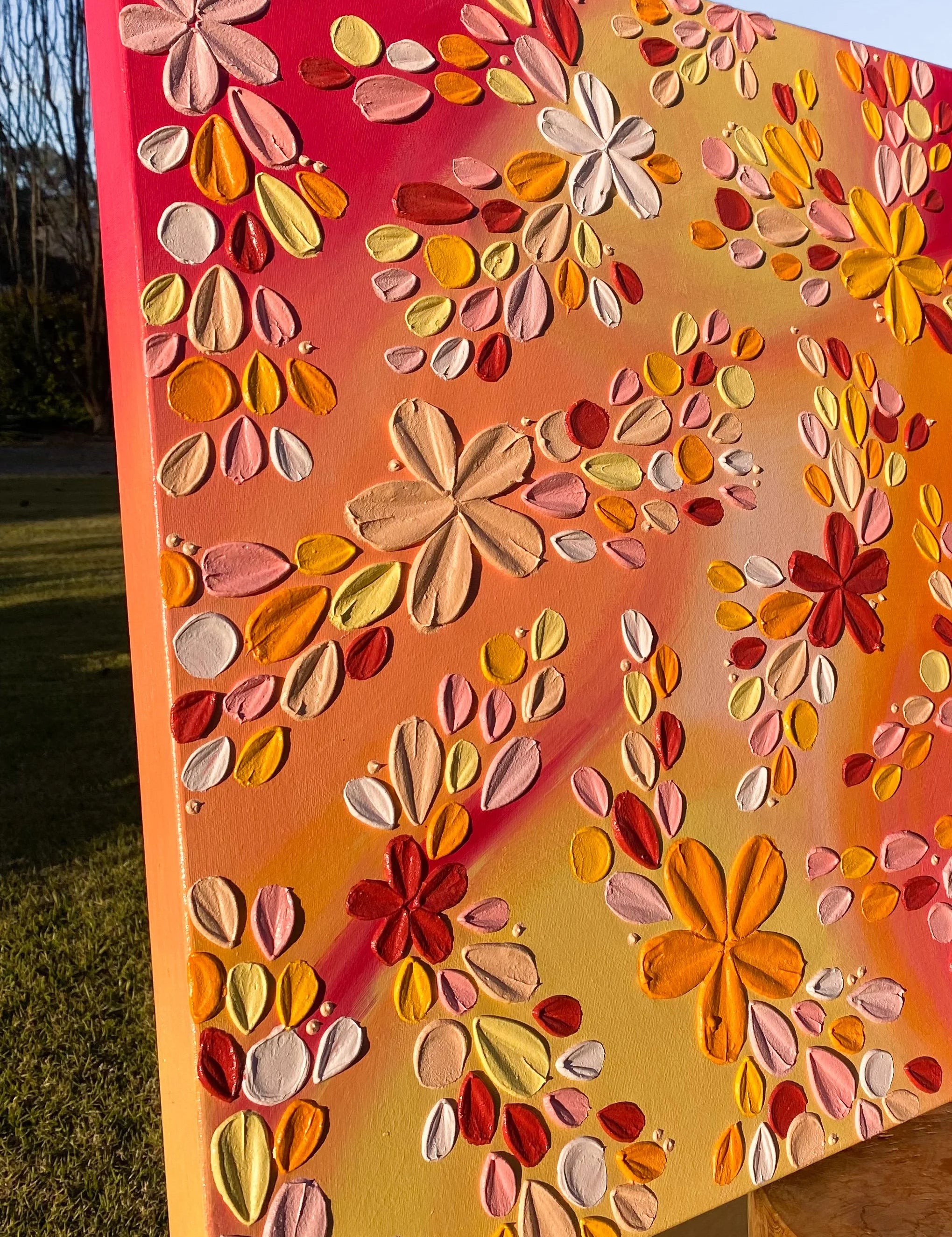 Colourful floral textured artwork with a blurred natural background